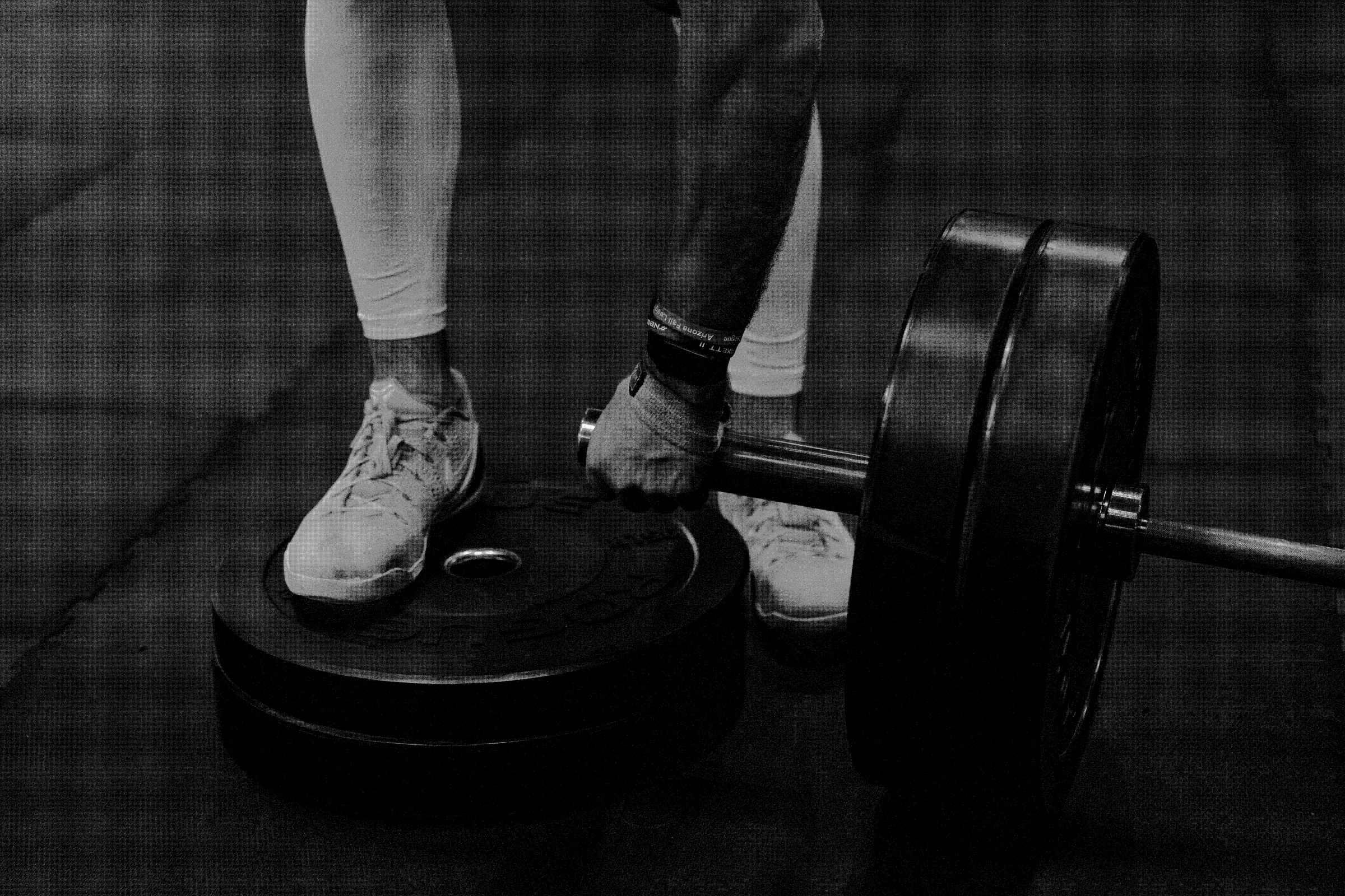 Athlete setting down a loaded barbell in the weight room